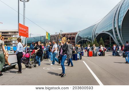 Moscow, Domodedovo, Russia - May 29, 2017: Place for smoking or smoking area with smoking people in front of the main entrance to Domodedovo airport