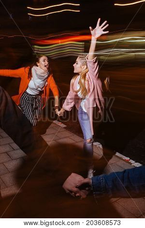 Hectic nightlife. Friendship never sleeps. Run and movement, youth leisure time, blurred background.