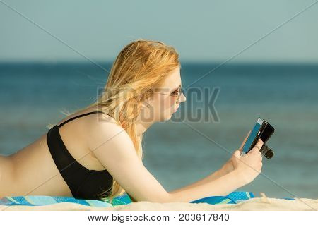 Woman In Bikini Sunbathing And Relaxing On Beach