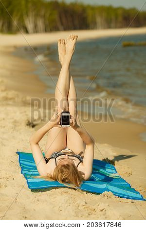Woman In Bikini Sunbathing And Relaxing On Beach