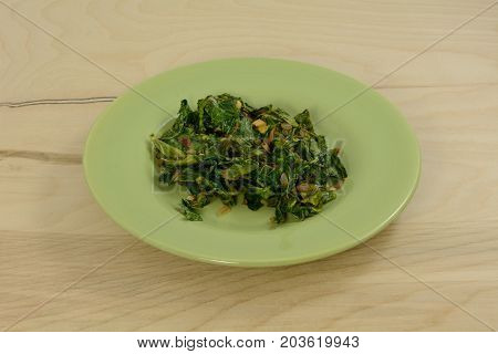 Cooked collard green salad on green plate