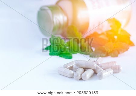 Vitamins Supplements Or Herbal In Bottle On White Table.