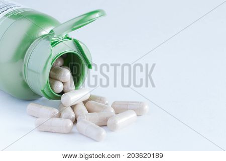 Vitamins Supplements Or Herbal In Bottle On White Table.