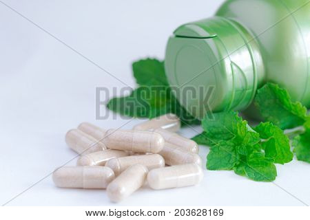 Vitamins supplements or herbal in bottle on white table.