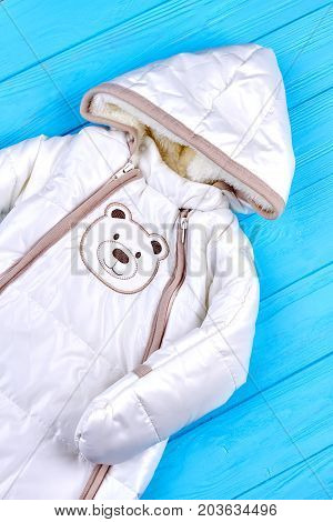 Cute winter romper for infant kids. Newborn baby boy romper, blue wooden background. Infant baby girls cotton overalls on sale.