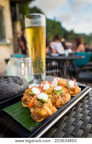 Indian Local food fusion on the wood plate with beer for outdoor restaurant dining in Rock Bar Bali Indonesia