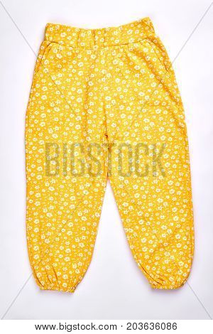 Baby-girl yellow patterned harems. Toddler girl cute design cotton pants isolated over white. Infant girls casual summer harems.