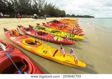 Labuan,Malaysia-Sept 9,2017:Colorful sea kayaks on sand beach with Malaysia flag in Labuan island,Malaysia.Malaysia is the ideal place for water sports,like white water rafting,kayaking,scuba diving & sailing.