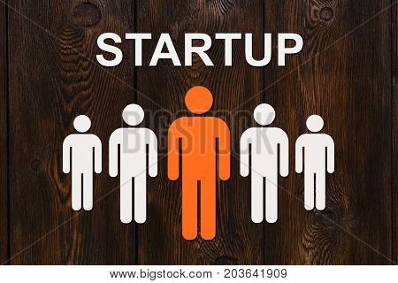 Business concept. Paper men on wooden background and text STURTUP. Abstract conceptual image