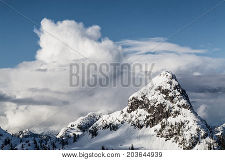 Aerial landscape view of the snow and cloud covered mountain range North of Vancouver British Columbia Canada.