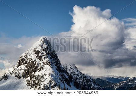 Aerial landscape view of the snow and cloud covered mountain range North of Vancouver British Columbia Canada.