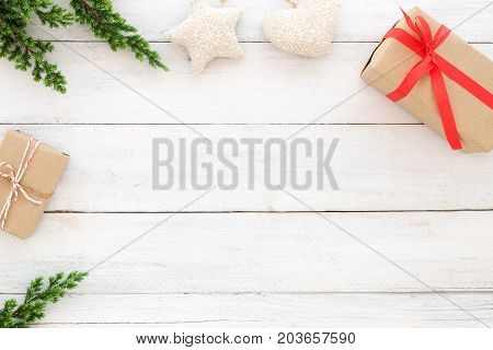 Christmas and New Year background. Christmas present gift boxes and fir leaves with decoration rustic elements on white wood background. Creative flat lay top view design