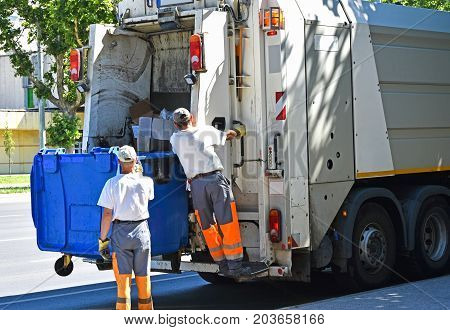 Garbage truck works in the city street