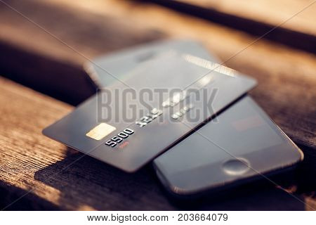 Credit card and mobile phone on a wooden background. Concept for mobile payments.