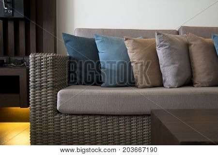 Wicker furniture and colorful cushions. Decoration of the living room in colorful theme.