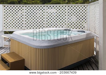 Wooden bathtub with swirling water at outdoor.
