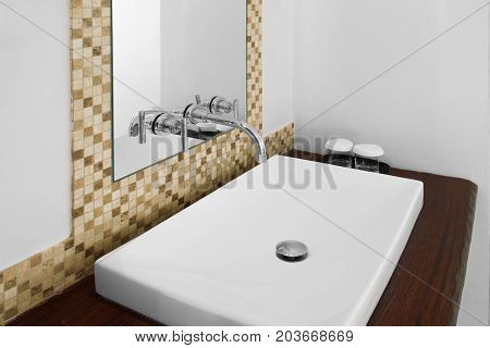 White washbasin and shiny faucet in clean restroom.