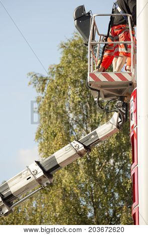 Workers in aerial work platform tending to sign.