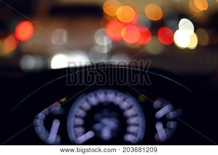 drive vehicle car travel road trip at city night with traffic light on street image focus steering wheel and blur bokeh abstract background