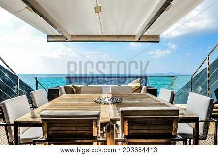 Dining table in yacht. Wooden table set.