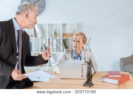 mature business colleagues discussing documents in office