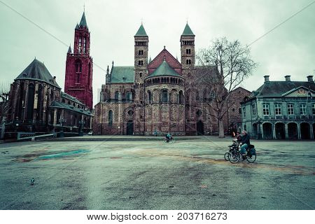 MAASTRICHT NETHERLANDS - JANUARY 09 2015: Vrijthof square. Evangelical Church of John the Baptist (left) and the Basilica of Saint Servatius (right). Vintage toning. Stylization.