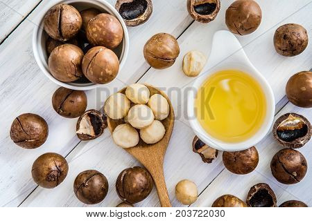 The Macadamia Nut Oil and peeled macadamia nut on white table ﻿use for Healthy Skin and Hair and Natural Healing Oil Treatment overhead and top view