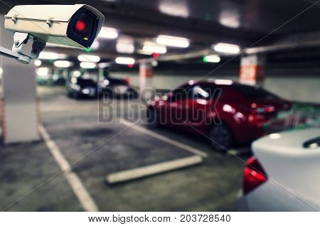 CCTV security indoor camera system operating with blurred image of under ground indoor car parking garage area RFID solution management system surveillance security and safety technology concept