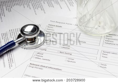 stethoscope test tube beaker and patient information form on desk heart healthcare technology medical diagnosis medical report record history patient concept soft and selective focus