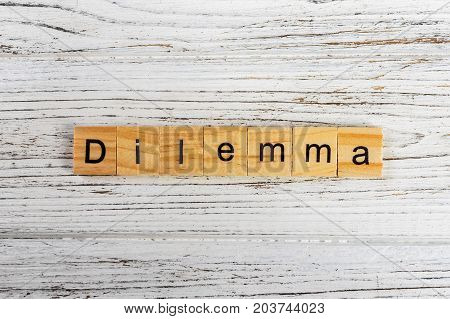 DILEMMA word made with wooden blocks concept