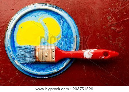 abstract oil paint with brush on red background close up.
