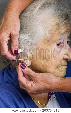 Senior Citizen and Hearing Aid
A carer fitting a senior ladies hearing aid.