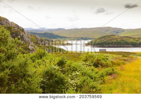 panorama of the Scottish moorland with house on the river shore of Scotland
