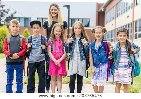 The Great Portrait Of School Pupil Outside Classroom Carrying Bags