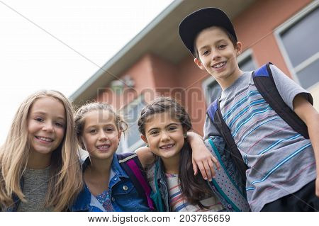 The Great Portrait Of School Pupil Outside Classroom Carrying Bags