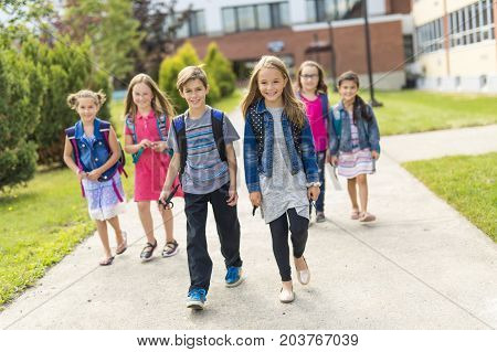 The Great Portrait Of School Pupil Outside Classroom Carrying Bags