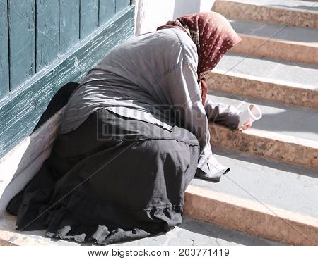Gypsy Woman With Headscarf And Long Skirt Begging People On The