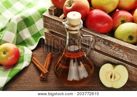 Apple Vinegar In Glass Bottle On Brown Wooden Table