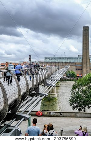 London UK - August 3 2017: Looking towards the Tate Modern accross the Millennium Bridge. Shows people walking over the bridge.