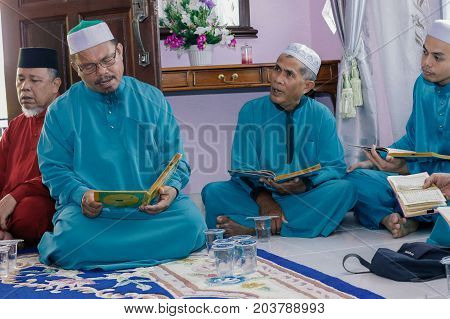 Labuan,Malaysia-Aug 30,2017:Muslim men perform Quran recitation during Aqiqah ceremony in Labuan,Malaysia.Islamic traditions after a baby is born include shaving his head & sacrificing an animal