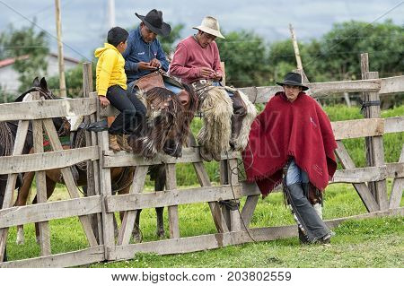 June 3 2017 Machachi Ecuador: cowboys from the Andes sitting on the fence in the morning in the high altitude town