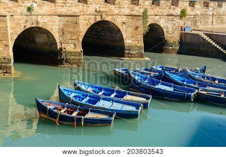 View of Old Fortress Sqala du Port and blue fishing boats in Essaouira. Morocco