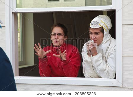 Two Women Discuss Construction Details While Standing In Window Frame For Habitat For Humanity