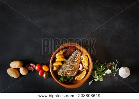 Baked dorado with fresh salad, vegetables and potato chips. Photo with copy space for your text