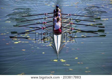 Males fours rowing team in race on the lake