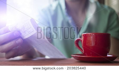 A man holding bill in a cafe