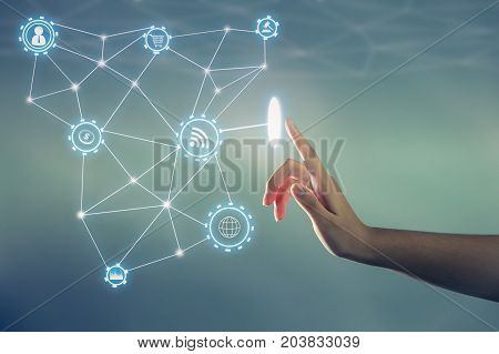 the hand touching the screen with a lot of icon throw out from screen technology about internet of thing concept.