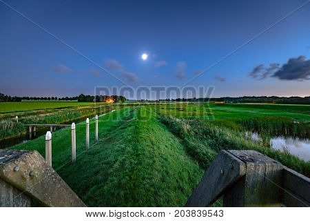 An old harbor head in the dry fallen polder of the Netherlands during sunset and the evening. A foot with contrasting and beautiful light
