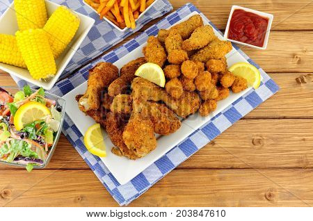 Collection of Southern fried chicken products with sweetcorn and salad