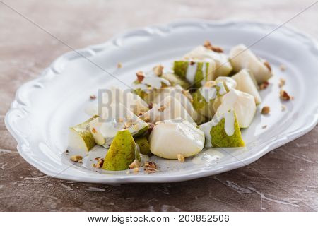 Delicious salad with pear, blue cheese sauce and almonds